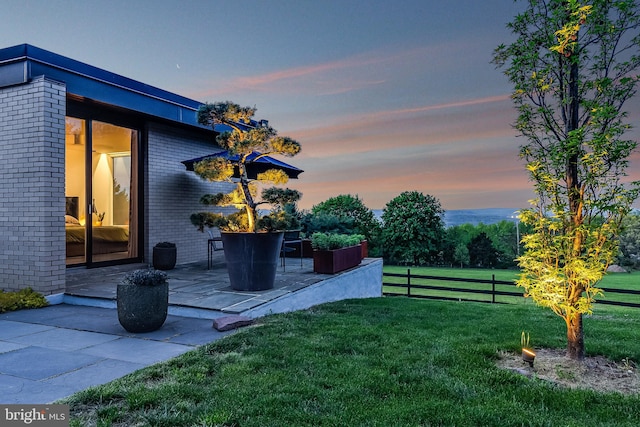 yard at dusk with a patio area