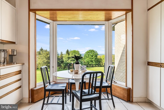 tiled dining space featuring wood ceiling and plenty of natural light