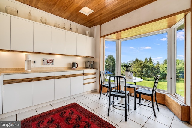 kitchen featuring wooden ceiling, white cabinets, and light tile patterned flooring