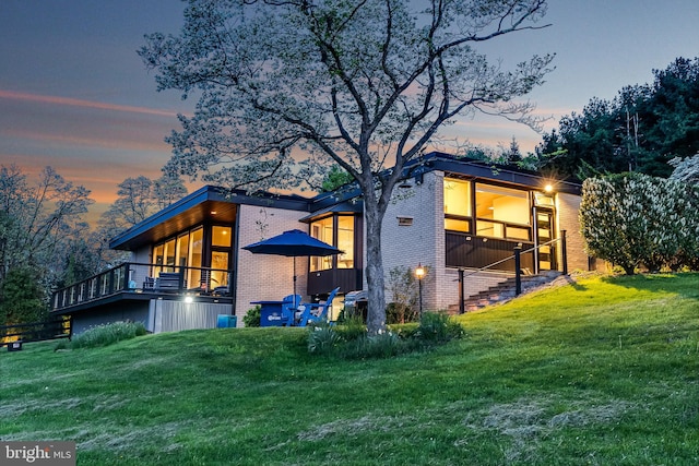 property exterior at dusk with a lawn