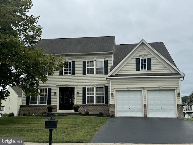 view of front of house with a front yard and a garage