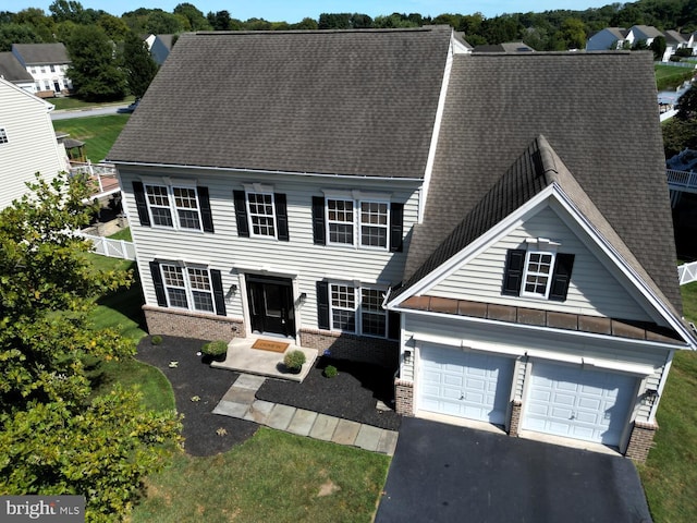 view of front of house featuring a garage, brick siding, roof with shingles, and aphalt driveway