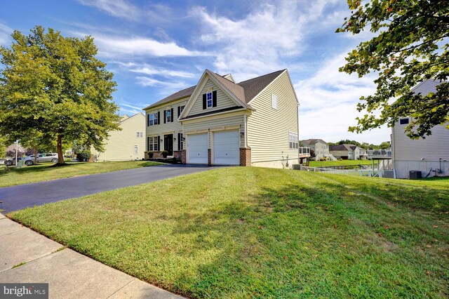 view of front of property featuring aphalt driveway, a front yard, a garage, and central air condition unit