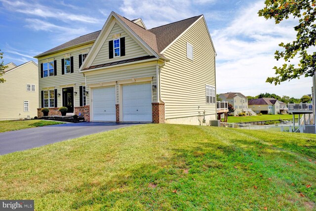 view of front facade featuring brick siding, driveway, and a front lawn