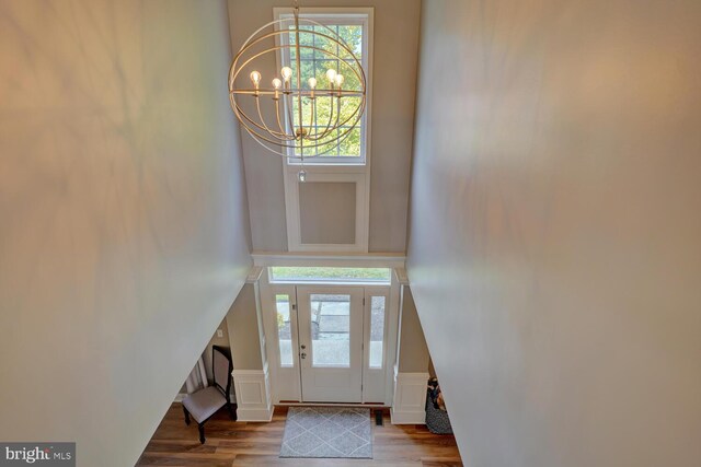 entrance foyer featuring wood finished floors and an inviting chandelier