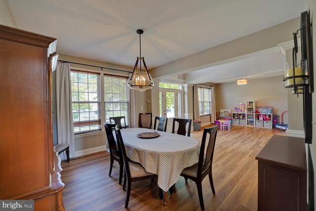 dining area with plenty of natural light, wood finished floors, and baseboards