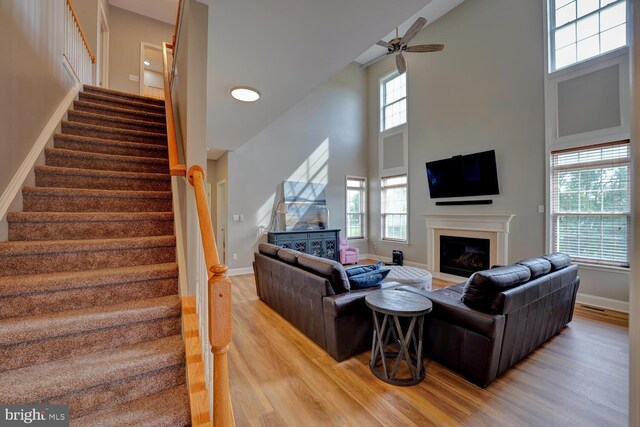 living room featuring a healthy amount of sunlight, light wood-style floors, and stairway