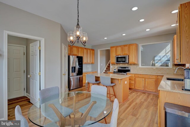 dining space with light wood-style floors, stairs, a notable chandelier, and recessed lighting