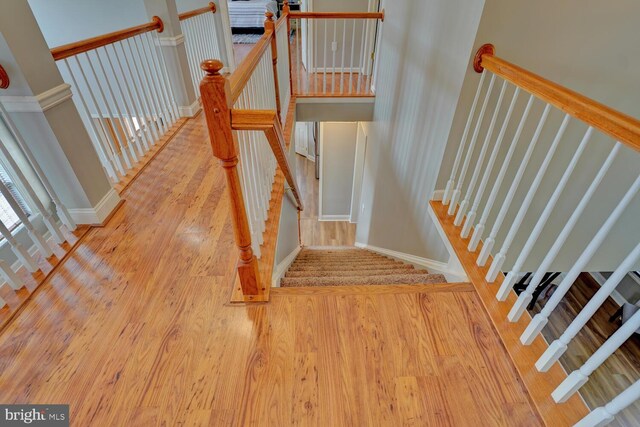 stairs with wood finished floors and baseboards