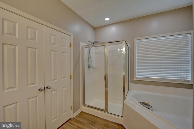 full bathroom featuring a garden tub, wood finished floors, and a shower stall