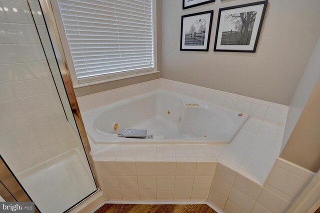 full bathroom with a whirlpool tub and a shower stall