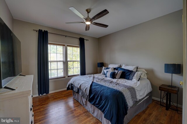 bedroom featuring ceiling fan, baseboards, and wood finished floors