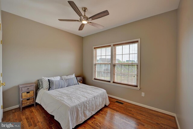 bedroom featuring baseboards, visible vents, ceiling fan, and dark wood-type flooring