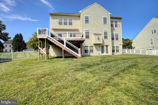 back of house featuring a fenced backyard, a lawn, a deck, and stairs