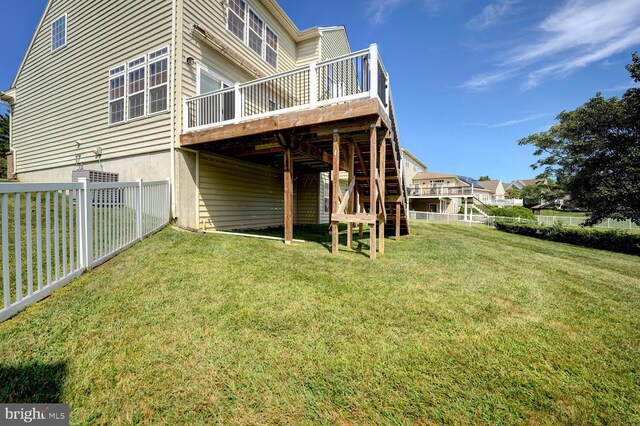 back of property featuring a fenced backyard, a lawn, and a wooden deck