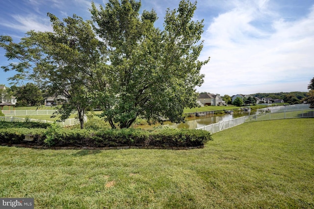 view of yard featuring a water view and fence