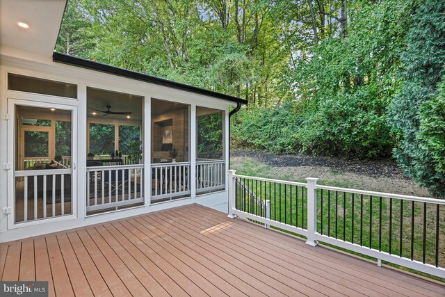 wooden terrace with a lawn and a sunroom