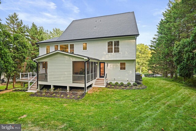 back of property with a sunroom and a lawn