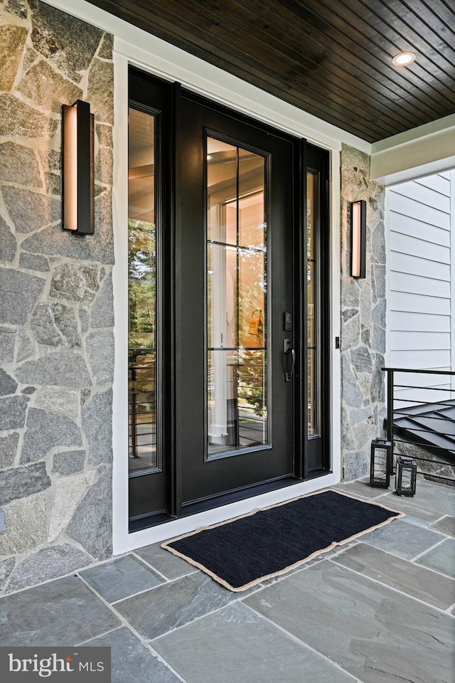 doorway to property with stone siding