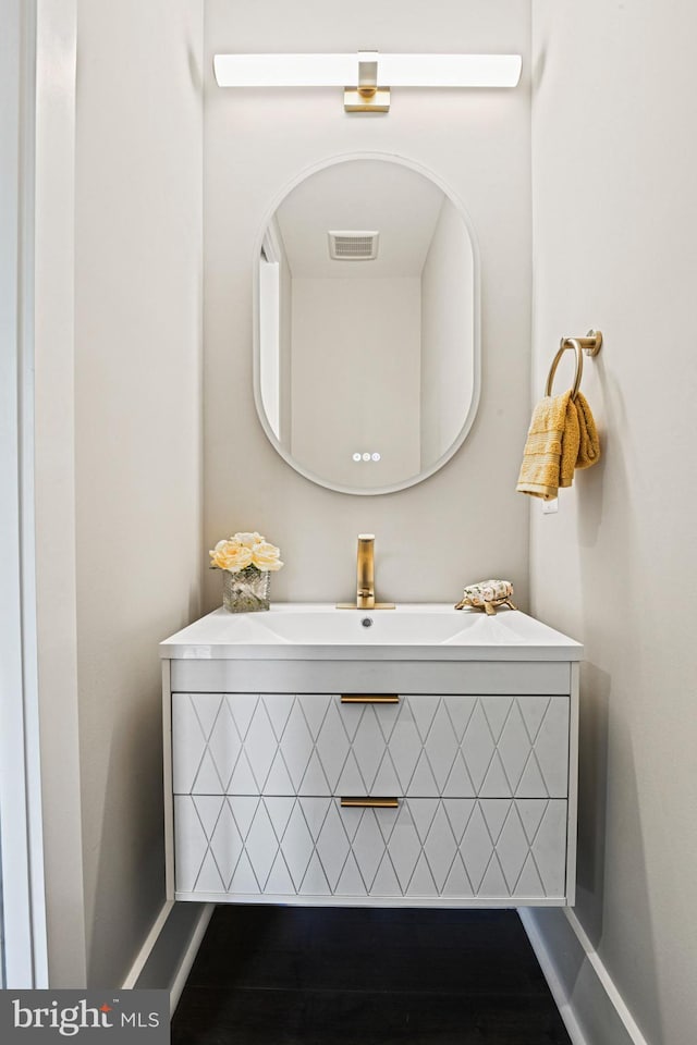 bathroom featuring baseboards, visible vents, and vanity