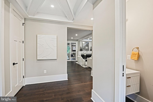 corridor featuring dark wood-style floors, recessed lighting, beamed ceiling, and baseboards