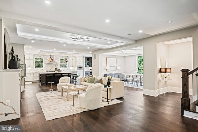 living room featuring plenty of natural light, stairs, and dark wood finished floors