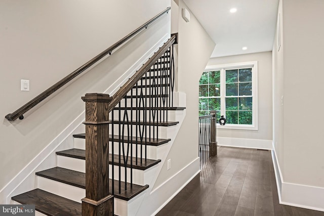 stairway featuring baseboards, wood finished floors, and recessed lighting