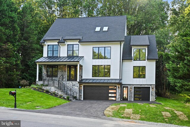 modern inspired farmhouse featuring a front yard, a garage, and a porch