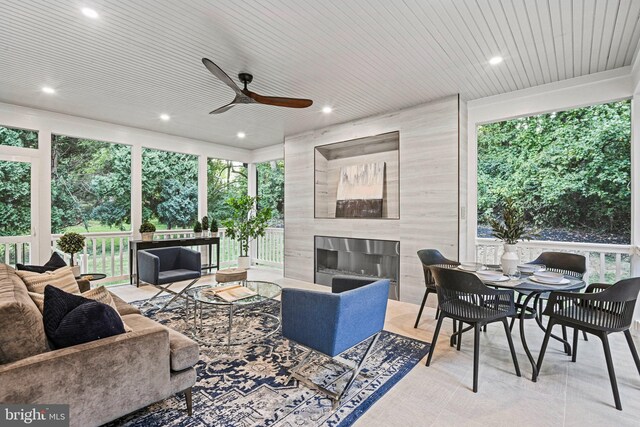 living room featuring ceiling fan and a premium fireplace