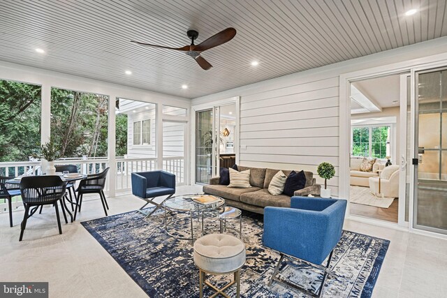 exterior space with wood ceiling, ceiling fan, and wood walls