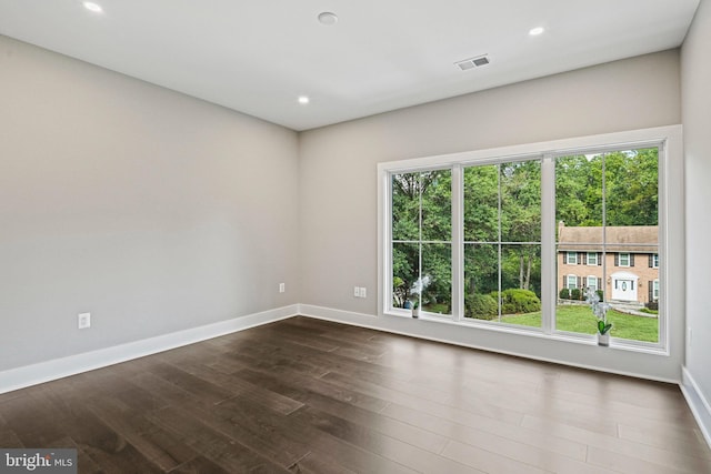 spare room featuring recessed lighting, visible vents, dark wood finished floors, and baseboards