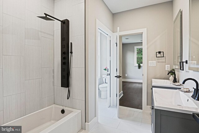 full bathroom with hardwood / wood-style floors, tiled shower / bath, toilet, and vanity