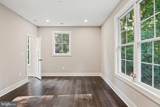 unfurnished room with dark wood-type flooring, recessed lighting, visible vents, and baseboards