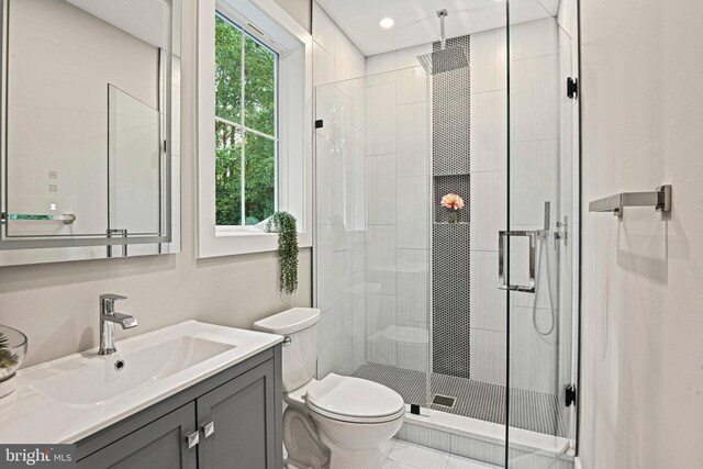 bathroom with a shower with shower door, toilet, a wealth of natural light, and vanity