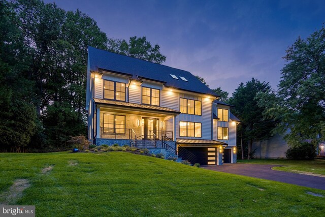 modern farmhouse style home featuring a porch, a garage, and a front lawn