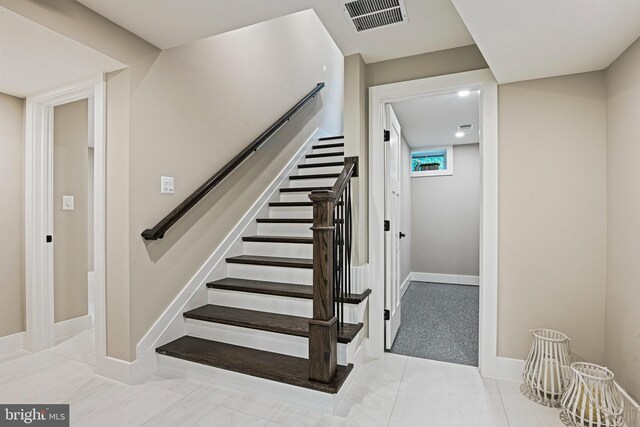 staircase featuring tile patterned flooring