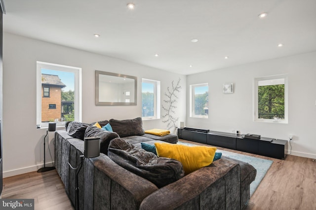 living room featuring recessed lighting, plenty of natural light, and light wood-style floors