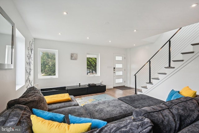 living area featuring stairs, baseboards, wood finished floors, and recessed lighting