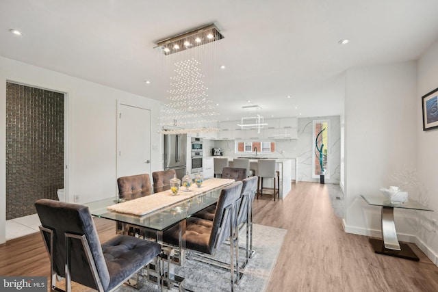 dining area with baseboards, recessed lighting, and light wood-style floors