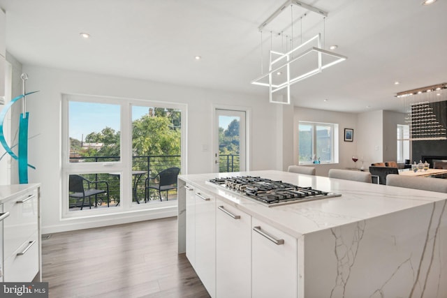 kitchen featuring dark wood finished floors, a healthy amount of sunlight, white cabinetry, and stainless steel gas stovetop