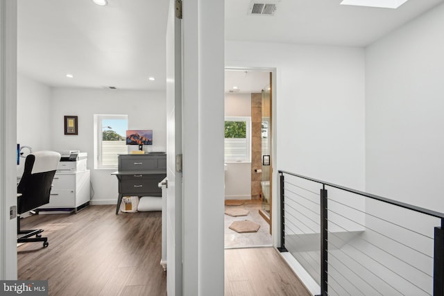 office space featuring a skylight, visible vents, recessed lighting, and wood finished floors