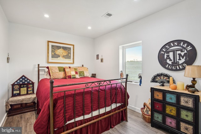 bedroom with visible vents, baseboards, and wood finished floors