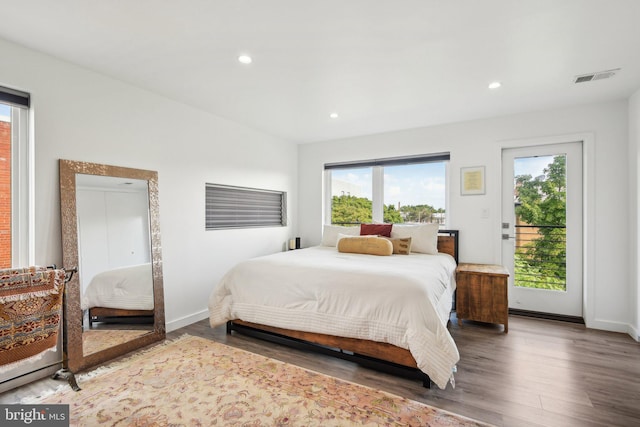 bedroom with access to exterior, recessed lighting, visible vents, and wood finished floors