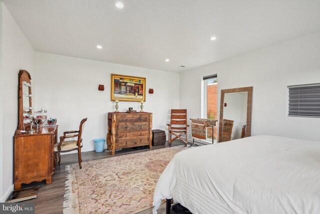 bedroom with baseboards, wood finished floors, and recessed lighting