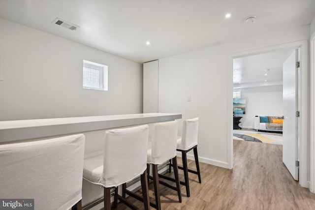 bar with baseboards, recessed lighting, visible vents, and light wood-style floors