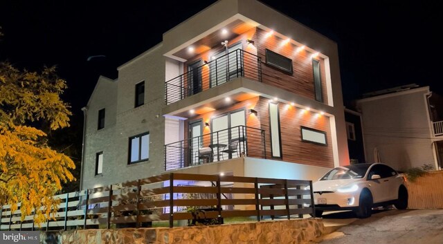 view of front of house featuring a balcony and stucco siding