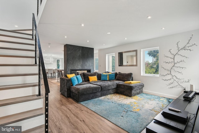 living area with stairs, baseboards, wood finished floors, and recessed lighting