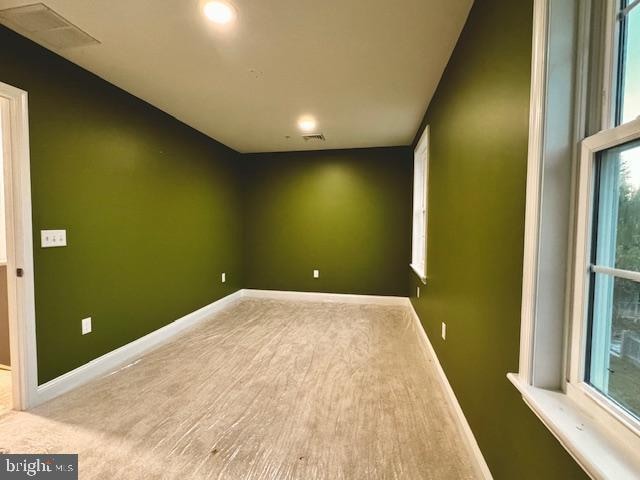 empty room with plenty of natural light and carpet floors