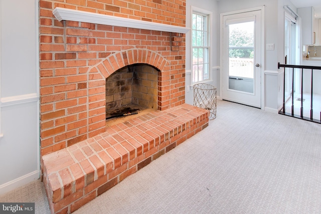 carpeted living room with a brick fireplace and baseboards