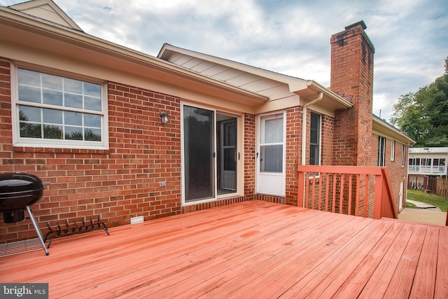 wooden deck featuring a grill